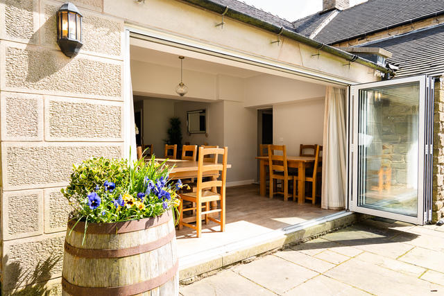Bifold doors in the dining room make the side patio area a great space for pre dinner drinks