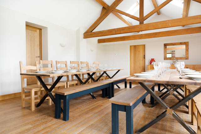 Dining space for up to 30 guests on a mix of chairs and benchs